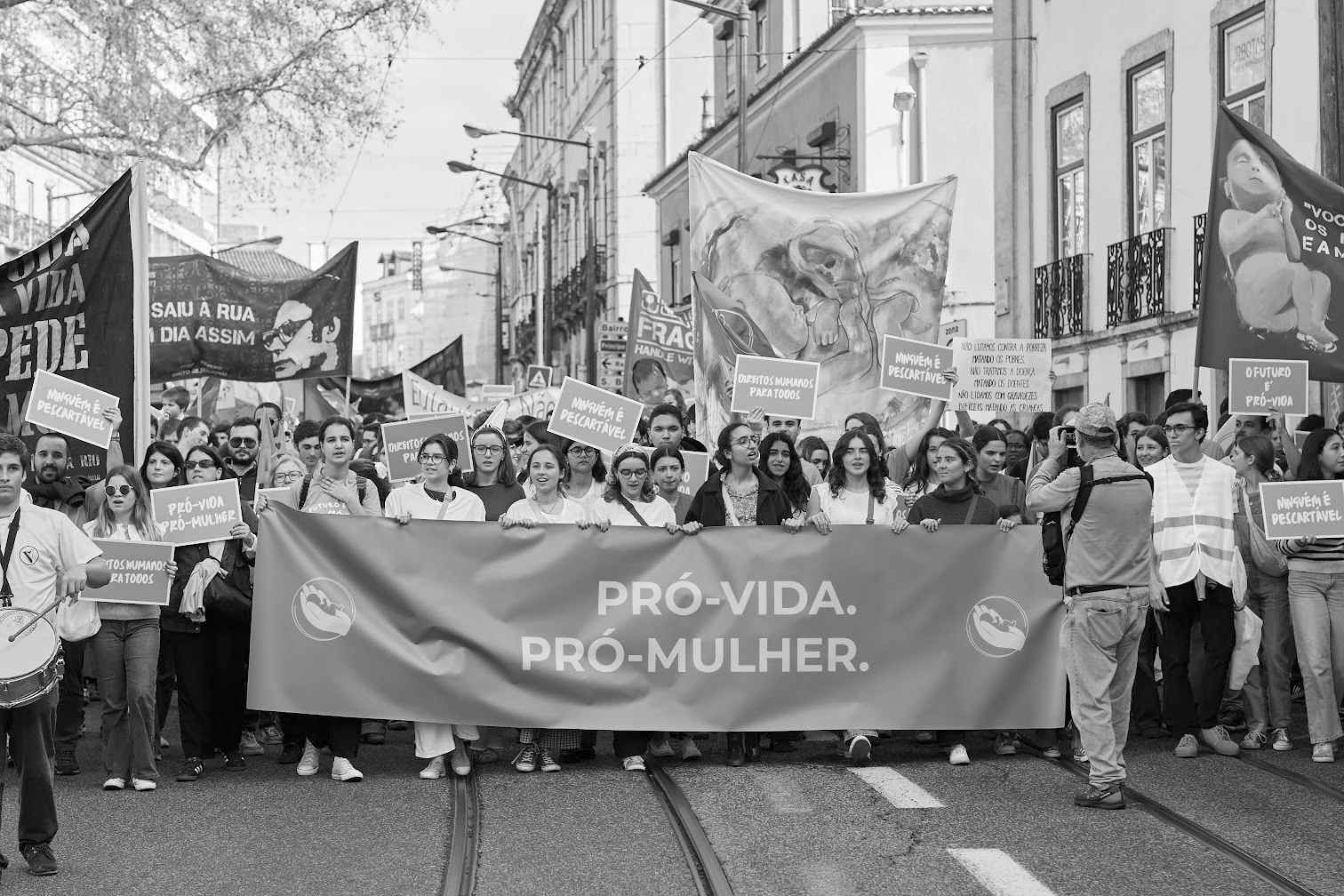 Grupo de manifestantes com cartazes e faixa